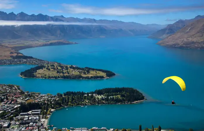 Wakatipu Gölü üzerinde yamaç paraşütü yapan bir maceracı