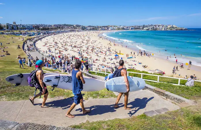 Sidney’de Bondi Beach sahilinin kumlarına inen sörfçüler