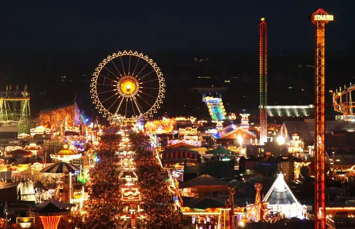 Oktoberfest gecenin içinde parlarken binlerce insan Oktoberfest'in atraksiyonlarını ziyaret ediyor.